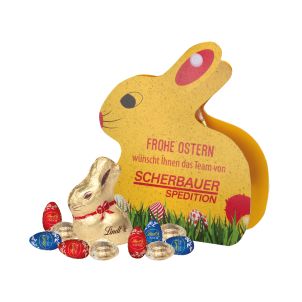 Werbe-Hase mit Goldhase und Schoko-Eier von Lindt auf Graspapier